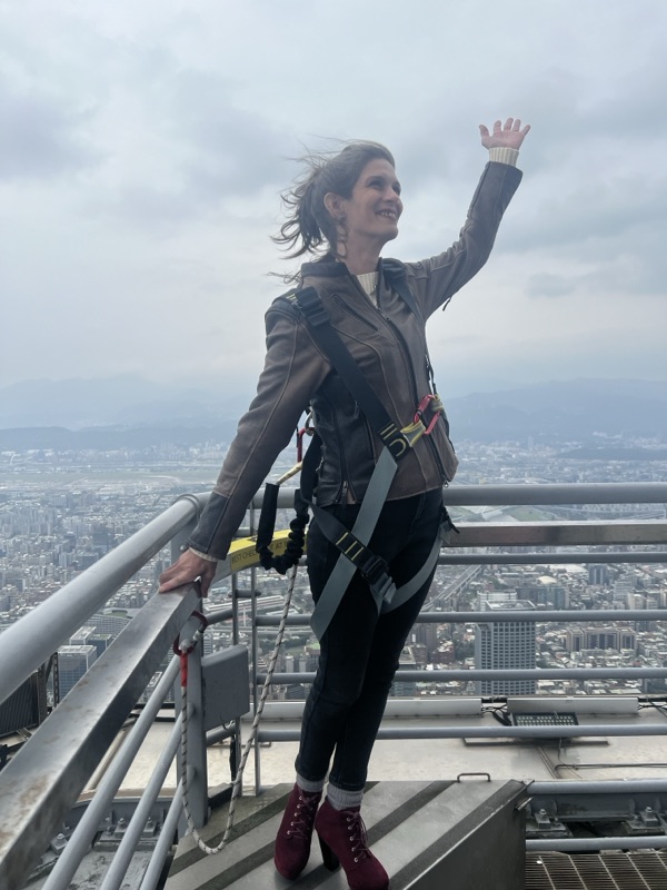 April on a skyscraper skywalk in a safety harness